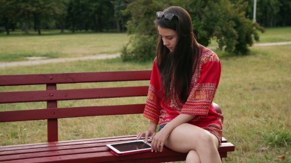 Young Woman Using Tablet Computer in Park