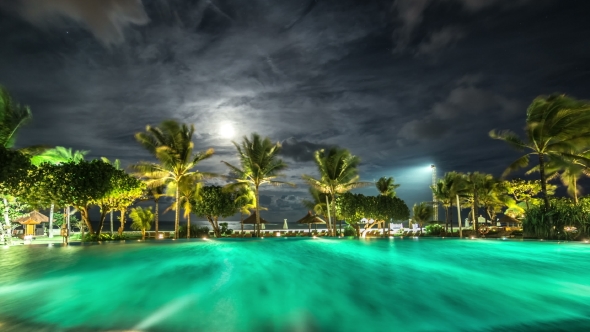 Illuminated Night Pool Against The Backdrop Of Palm Trees And The Sea.   - Bali, Indonesia, June