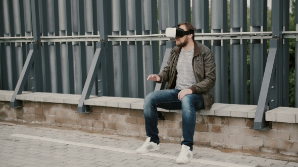 Bearded Attractive Man Uses Virtual Reality Glasses On The Roof, Takes Off His Glasses And Walks