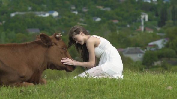 Happy Girl Strokes A Cow At Summer Day