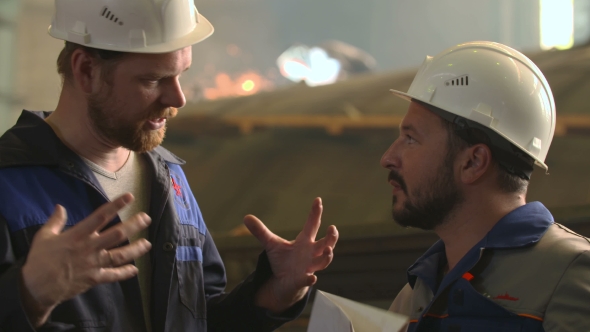 Portrait Of Two Engineers Explore And Discuss Project In Heavy Industry Factory. Welding Background