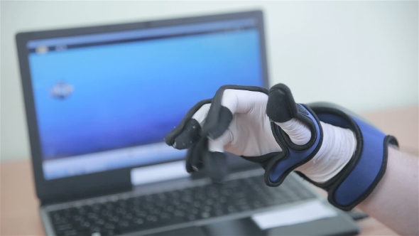 Electronic Robotic Cyber Glove. Man Plays VR Game Operating With 3D Bionic Simulator Glove.