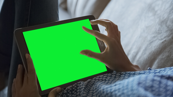 Beautiful Girl Using Tablet PC with Green Screen Laying on Sofa at Home 2