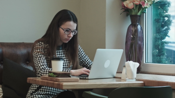 Woman On Lunch Break In Cafe Drinks Coffee Use Laptop