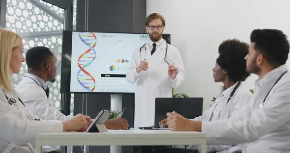 Doctor Holding a Presentation on Interactive Screen on Dna Theme for His colleagues