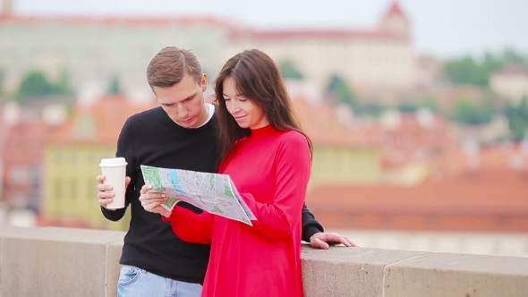 Young Tourist Couple Traveling On Holidays In Europe Smiling Happy. Caucasian Family With City Map