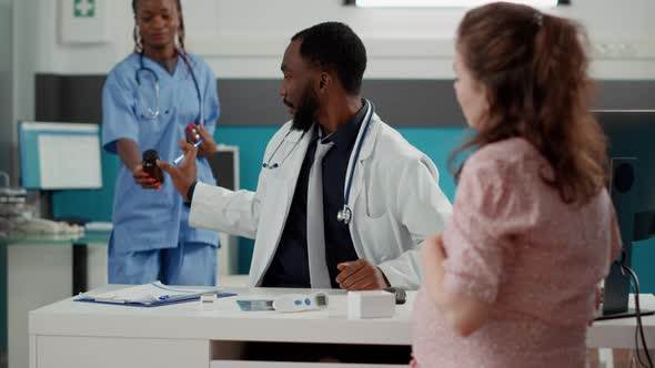 Medical Specialist Giving Prescription Pills in Bottle to Expectant Patient