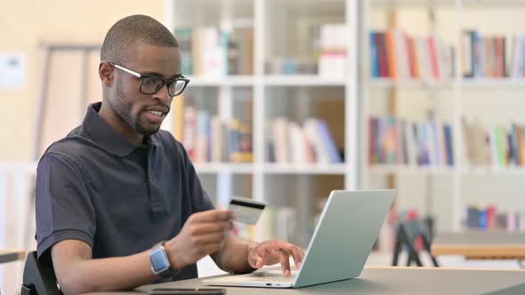 Online Payment Success By Young African Man on Laptop in Office