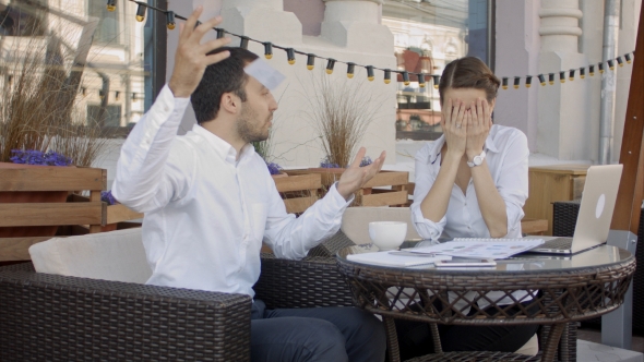 Emotional Young Businessman Tearing Paper On Business Meeting