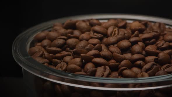 Close Up Slow Camera Pan Over a Glass Plate Filled with Coffee Beans on a Dark Background