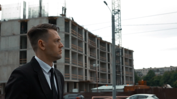 Businessman In Suit Walking Near Newly Constructed Building