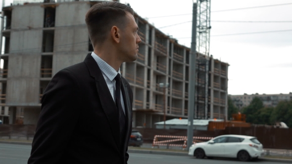 Businessman In Suit Walking Near Newly Constructed Building