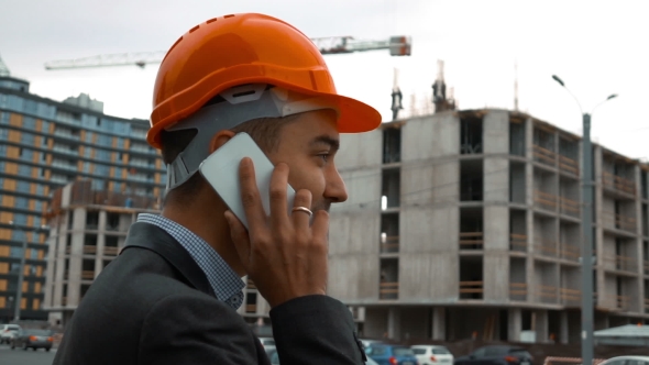 Builder In a Orange Helmet Is Making Call