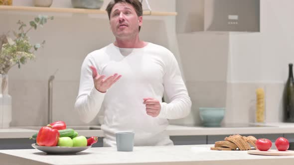 Happy Middle Aged Man Dancing While Drinking Coffee in Kitchen