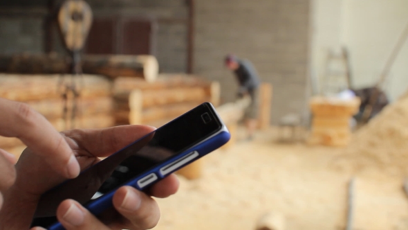 Young Man Forestry Engineer Touch Phone In Front Of Wood