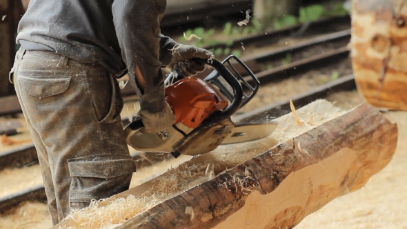 Man Cuts Off Beam Chainsaw For Future Home. Construction Works With a Wooden Structure. 