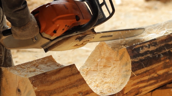 Man Cuts Off Beam Chainsaw For Future Home. Construction Works With a Wooden Structure. 