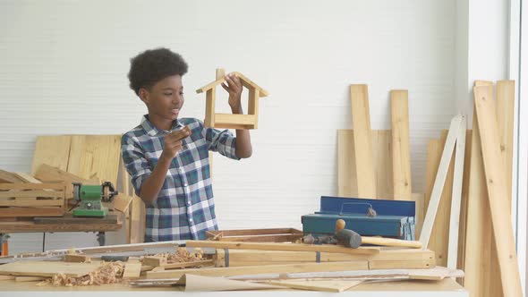 Smiling african american kid carpenter happy working with wood and sandpaper, Education, learning 