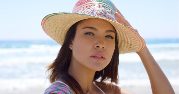 Smiling Young Woman Holding Her Sunhat