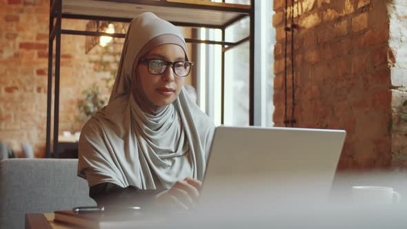Business Lady in Hijab Working on Laptop in Cafe