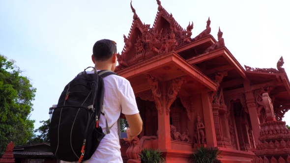 Young Male Traveler Taking Photo Of Asian Buddhist Temple.