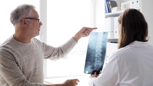 Doctor Showing X-ray To Senior Man At Clinic  73