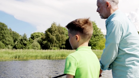 Grandfather And Grandson Fishing On River Berth 5