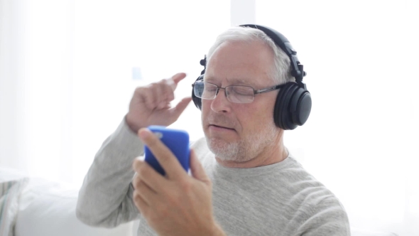 Happy Senior Man With Smartphone And Headphones 16