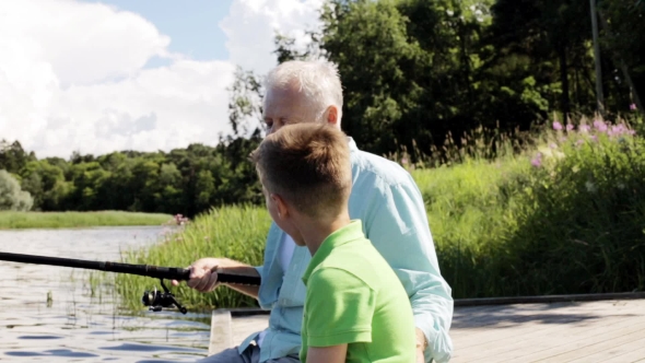 Grandfather And Grandson Fishing On River Berth 7