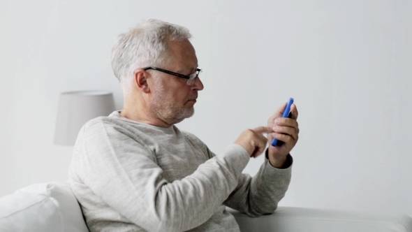 Happy Senior Man Calling On Smartphone At Home 100