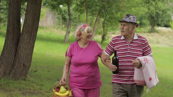 Family Weekend Picnic. Active Senior Old Grandparents Couple in Park. Husband and Wife Walk Together