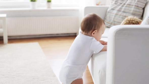 Little Baby Standing And Holding To Sofa At Home 5