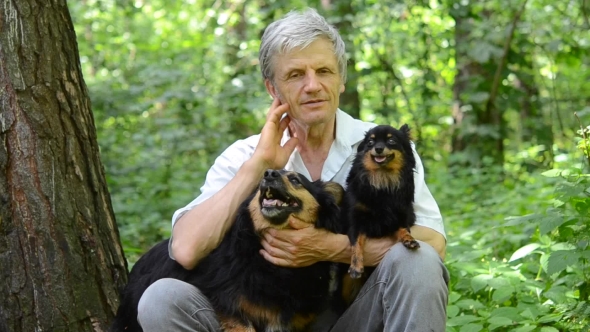 Man With Gray Hair And Dog Sitting In The Forest