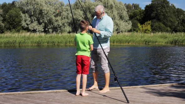 Grandfather And Grandson Fishing On River Berth 1