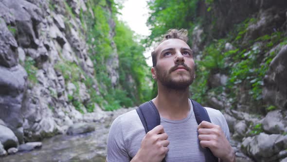 The man standing in the canyon looks around.