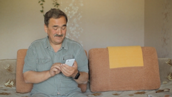 Senior Man With a Mustache Touching The Mobile Phone. He Wrote In The Social Network