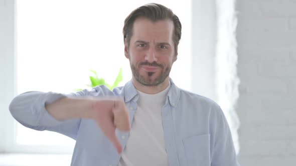 Portrait of Young Man Showing Thumbs Down Gesture