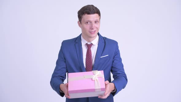 Happy Young Handsome Businessman Giving Gift Box