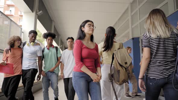 Nerd Teenage Girl Standing in School Hallways As Boys Following and Laughing