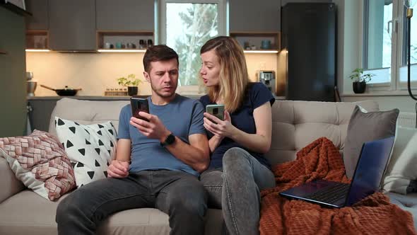 Couple Using Smartphone in Living Room