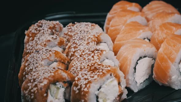 Sushi Rolls Rotating in Plastic Box