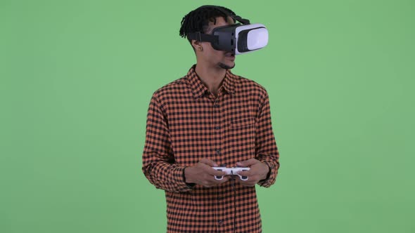 Happy Young African Man Playing Games with Virtual Reality Headset