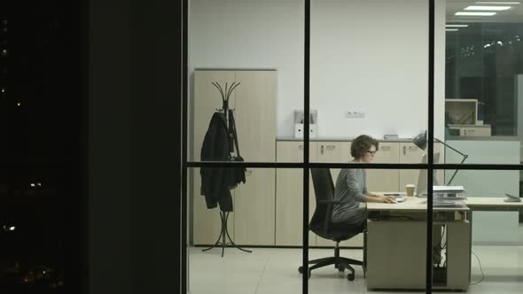 Woman Typing Report in Modern Glass Office