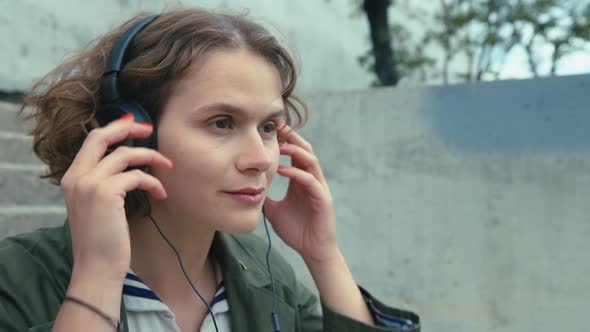 Young Millennial Woman Put on Headphones