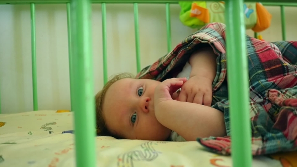 Beautiful Baby Lying Awake In Crib