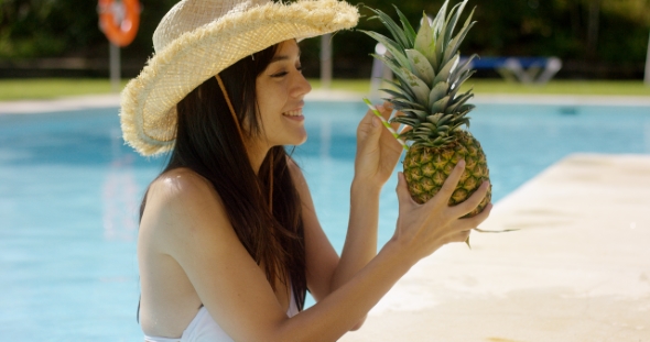 Young Woman Sipping a Pineapple Cocktail