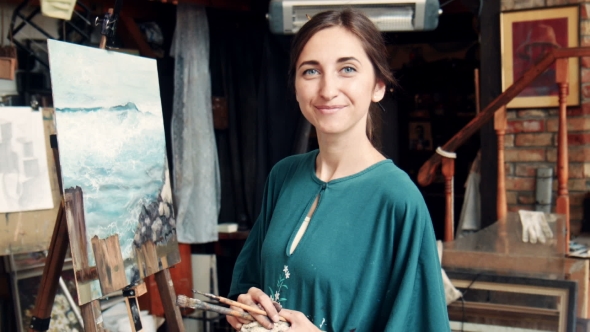 Portrait Of Young Woman Painting a Canvas In a Studio