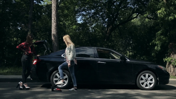 Young Woman Inflating Car Tyre With Foot Pump