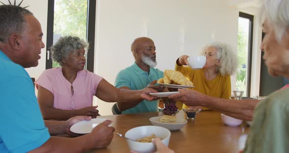 Happy senior diverse people having breakfast at retirement home