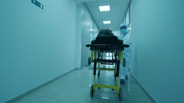 One Doctor Carries a Man on Stretcher in Clinic During Pandemic